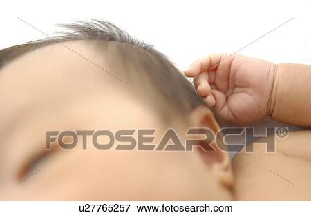 Stock Photo - Baby sleeping on bed, white background, differential focus. Fotosearch