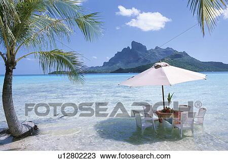 Stock Image - Beach Umbrella and Table on the Beach. Fotosearch