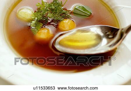 Stock Image - Bowl of consomme soup, close up. Fotosearch