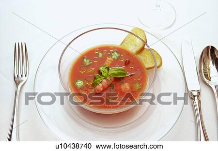 Stock Image - Bowl of shrimp gazpacho, white background. Fotosearch