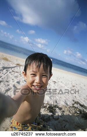 Boy at beach looking at camera, Saipan, USA View Large Photo Image Stock Photo - Boy at beach looking at camera, Saipan, USA. Fotosearch