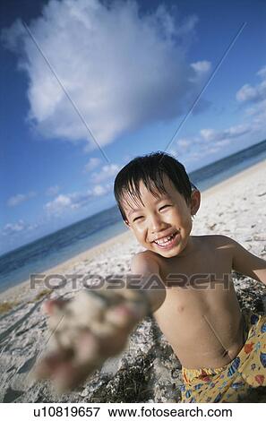 Stock Photo - Boy at beach looking at camera. Fotosearch