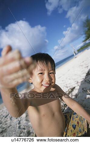 Boy at beach looking at camera View Large Photo Image Stock Photograph - Boy at beach looking at camera. Fotosearch