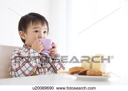 Stock Image - Boy drinking juice from a plastic cup. Fotosearch