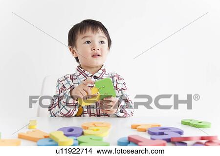 Picture - Boy playing with alphabet and number toys. Fotosearch