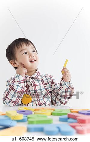 Stock Photography - Boy playing with alphabet and number toys. Fotosearch