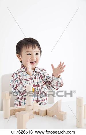 Boy playing with wooden building block View Large Photo Image Stock Image - Boy playing with wooden building block. Fotosearch