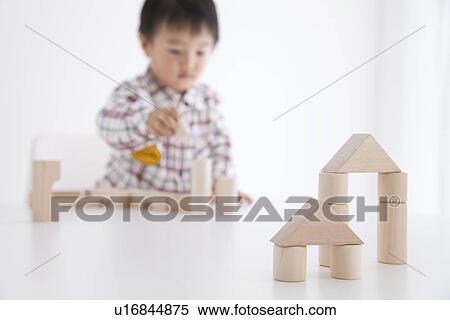 Stock Photography - Boy playing with wooden building block. Fotosearch