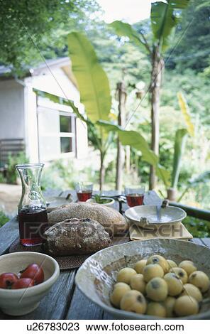 Stock Image - Bread and Red Wine on the Table in the Garden. Fotosearch
