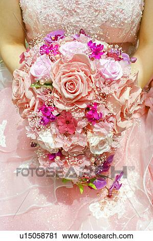 Stock Image - Bride holding flower bouquet, close up. Fotosearch