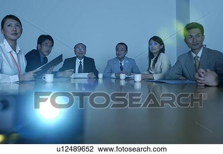 Stock Image - Business Men and Business Women at Meeting, Looking at Screen. Fotosearch