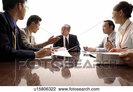 Stock Image - Business Men and Business Women at Meeting. Fotosearch