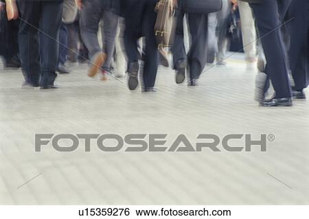 Stock Photograph - Business people walking down the street, blurred motion, copy space. Fotosearch