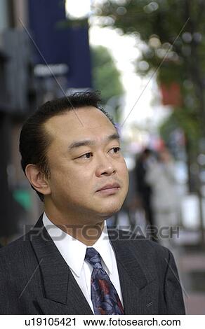 Stock Image - Businessman at street, differential focus, Tokyo prefecture, Japan. Fotosearch