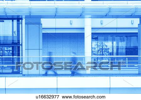 Stock Photo - Businessmen walking for work, toned image, blurred motion, Tokyo prefecture, Japan. Fotosearch