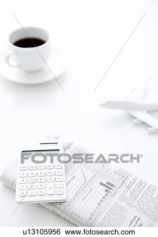 Calculator on newspaper, cup of coffee and toy airplane on white background View Large Photo Image Stock Photograph - Calculator on newspaper, cup of coffee and toy airplane on white background. Fotosearch