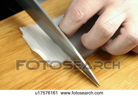 Stock Image - Chef cutting squid, close up. Fotosearch
