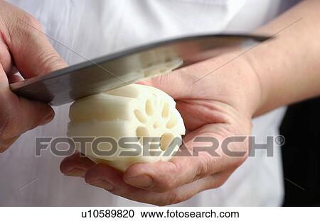 Stock Image - Chef peeling lotus root, close up. Fotosearch