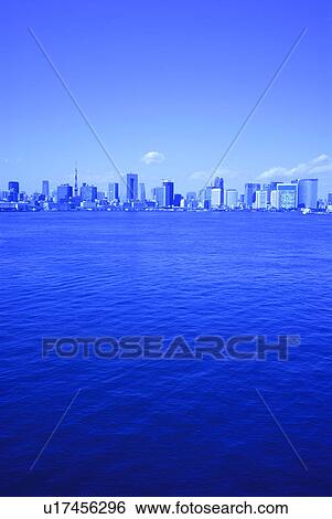 Stock Photograph - Cityscape beyond Tokyo bay, toned image, copy space, Tokyo prefecture, Japan. Fotosearch