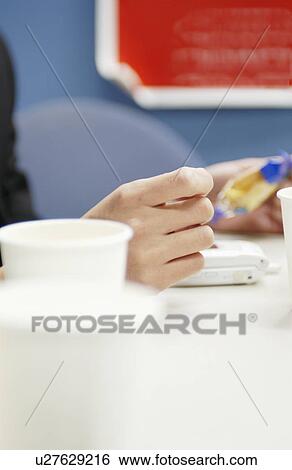 Stock Photograph - Close Up Image of Hands on Desk in Office. Fotosearch