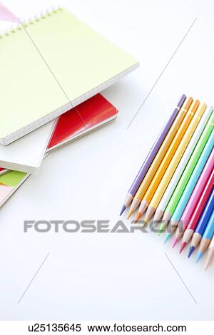 Stock Photography - Colored pencils and note pads on white background. Fotosearch