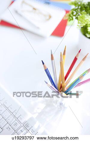 Stock Photo - Colored pencils on desk in office, white background. Fotosearch