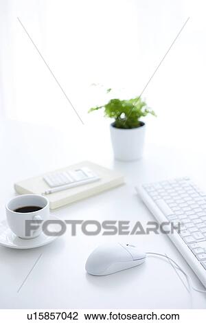 Stock Image - Computer and cup of coffee on desk in office. Fotosearch