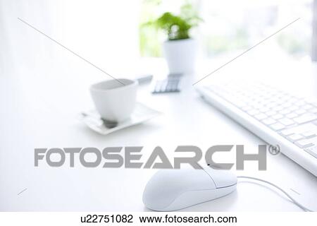 Stock Image - Computer and cup of coffee on desk in office. Fotosearch
