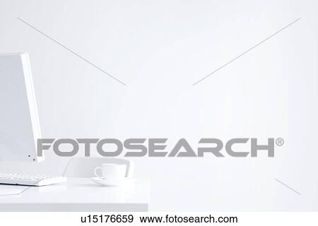 Stock Photo - Computer and cup of coffee on desk in office, white background, copy space. Fotosearch