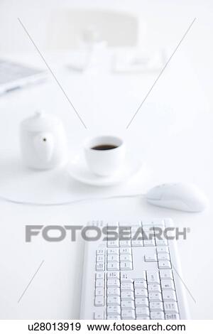 Computer keyboard and cup of coffee on desk in office View Large Photo Image Stock Photo - Computer keyboard and cup of coffee on desk in office. Fotosearch