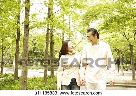 Stock Image - Couple taking a walk at a park. Fotosearch