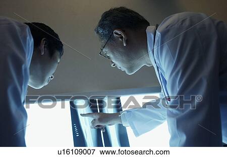 Doctors discussing X-rays View Large Photo Image Stock Photo - Doctors discussing X-rays. Fotosearch