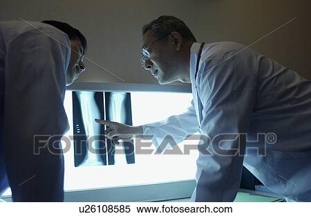 Doctors discussing X-rays View Large Photo Image Stock Photography - Doctors discussing X-rays. Fotosearch