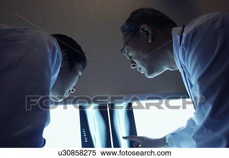 Stock Photography - Doctors discussing X-rays. Fotosearch