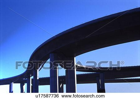 Stock Photograph - Elevated road against sky, blue background, Tokyo prefecture, Japan. Fotosearch