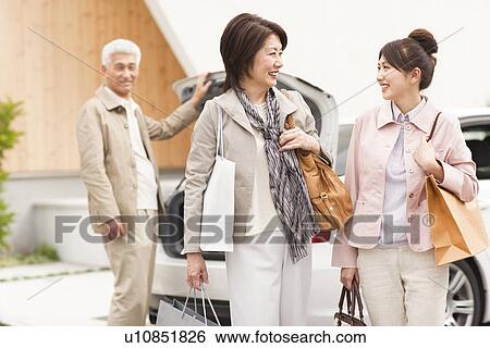 Family holding shopping bags, senior man standing by car, smiling View Large Photo Image Stock Photograph - Family holding shopping bags, senior man standing by car, smiling. Fotosearch