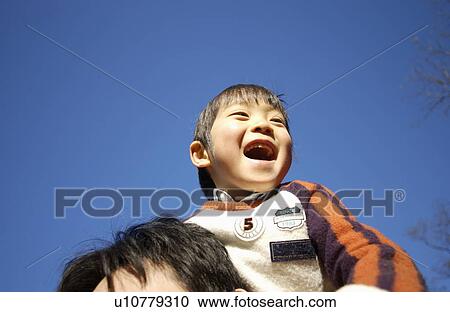 Stock Image - Father carrying son on shoulders, Tokyo Prefecture, Honshu, Japan. Fotosearch