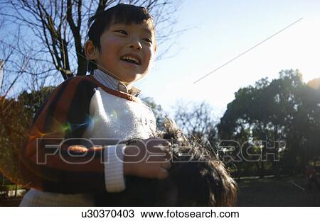 Stock Image - Father carrying son on shoulders, Tokyo Prefecture, Honshu, Japan. Fotosearch