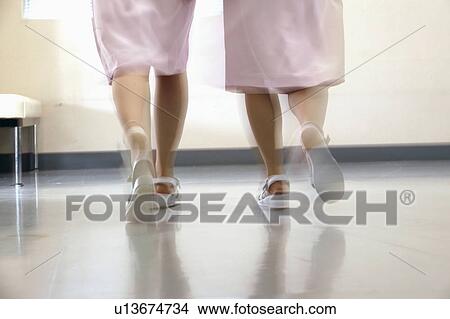 Picture - Female nurses walking in corridor quickly, blurred motion. Fotosearch