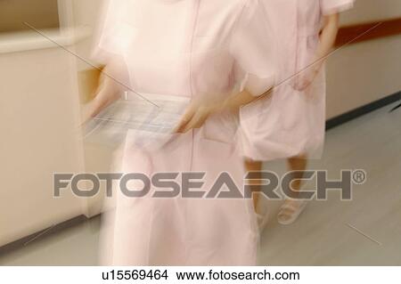 Picture - Female nurses walking in corridor quickly, blurred motion. Fotosearch