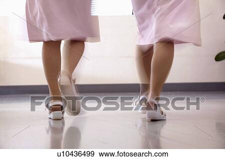 Stock Photo - Female nurses walking in corridor quickly, blurred motion. Fotosearch