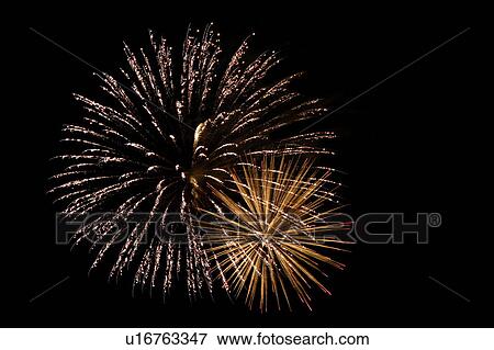 Stock Photo - Fireworks exploding in sky, black background, long exposure. Fotosearch