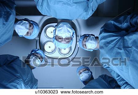 Stock Image - Five surgeons from operating table. Fotosearch