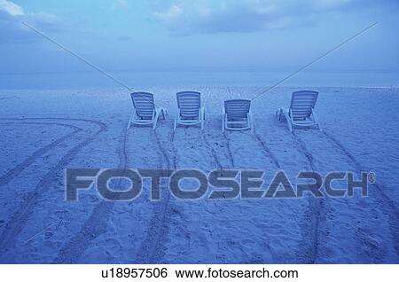 Stock Photograph - Four deck chairs on beach, Maldives. Fotosearch