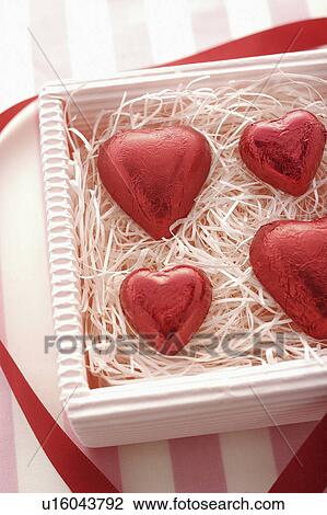 Stock Image - Four Red Heart Chocolates in Box. Fotosearch