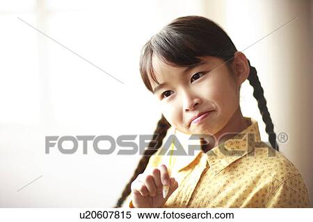 Stock Photography - Girl putting head on pencil, Kobe city, Hyogo prefecture, Japan. Fotosearch