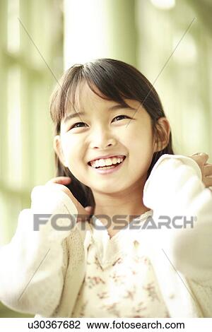 Stock Image - Girl smiling neat window. Fotosearch