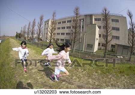 Stock Image - Girls running on riverbank, fish-eye lens. Fotosearch