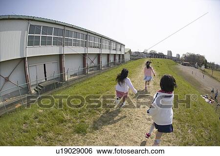 Stock Photograph - Girls running on riverbank, fish-eye lens. Fotosearch