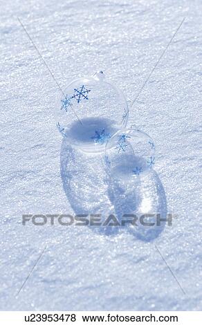 Stock Photo - Glass balls with snowflakes on snow. Fotosearch